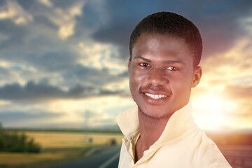 Happy young man smiling in camera on the outdoor background