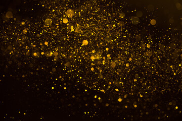 Golden shimmering glitter particles lights abstract background