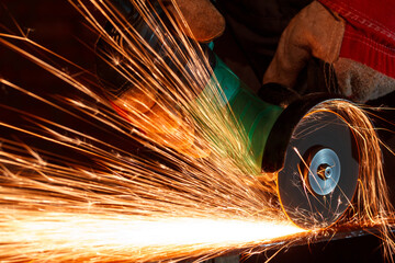 Industrial worker grind metal with sparks