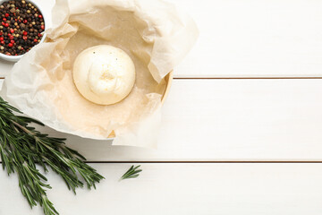 Delicious burrata cheese with rosemary and peppercorns on white wooden table, flat lay. Space for text