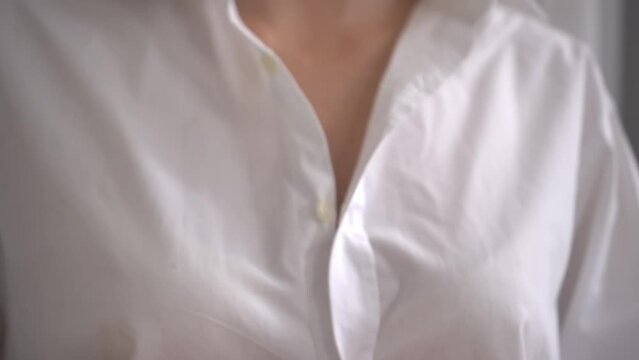 An unrecognizable white woman unbuttons her shirt and exposes her bra. Preparation for breast examination or before sex. Sexy blonde. Sexy slim woman. hands of a woman in close-up.