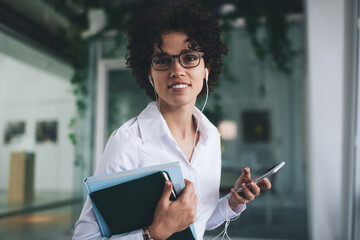 Woman listening music in earphones on smartphone