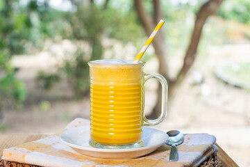 A cup of hot curcuma latte on wooden floor