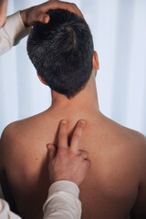 Man receiving relaxation treatment from physiotherapist or homeopath for pain relief.