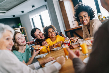 Multiethnic diverse extended family dining and toasting together - Powered by Adobe