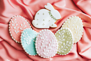 background banner greeting card for Happy Easter with set colorful eggs, Easter bunny rabbit gingerbread cookies on pink silk fabric background