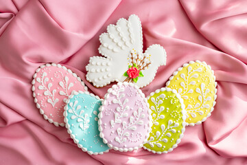 background banner greeting card for Happy Easter with set colorful eggs, Easter bird gingerbread cookies on pink silk fabric background