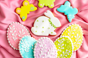 background banner greeting card for Happy Easter with set colorful eggs, Easter bunny rabbit gingerbread cookies on pink silk fabric background
