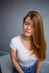 Portrait of a young beautiful woman with blond hair of European appearance. Dressed in a white T-shirt. Emotional photo of a person