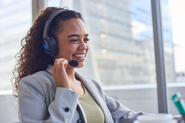 A young agent holds the headset microphone and smiles- skyscraper background