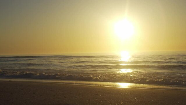 Scenic sunset over beach landscape, waves crashing over the horizon at Assateague Island National Park.