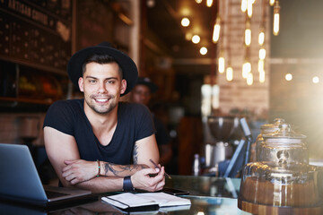 I know the coffee business inside out. Shot of a handsome young man working behind the counter of a coffee shop.