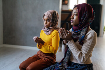 Muslim family praying together. Religious activity concept