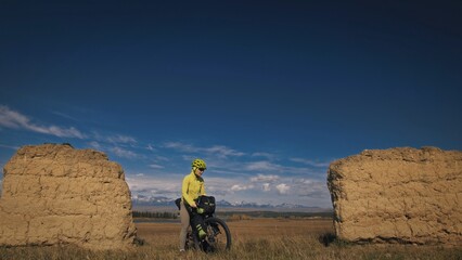 The woman travel on mixed terrain cycle touring with bikepacking. The traveler journey with bicycle...