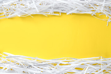 Shredded paper strips on yellow background, flat lay. Space for text