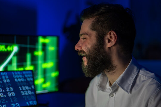 Male Investor Getting Excited With Laptop With Financial Market Chart Graphic Going Up. Happy Trader With Good Exchange Of Bitcoin At Online Stock Platform.