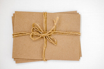 Kraft envelopes tied with a gray rope (tow) on a light background. copy space.