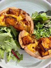 Pumpkin quiche with salad on the plate