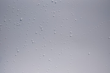 Close up of water drops on white tone background. Abstract white wet texture with bubbles on plastic PVC surface or grunge. Realistic pure water droplets condensed. Detail of canvas leather texture