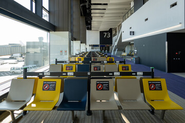 Social distance signs at empty airport boarding gate in vacant terminal