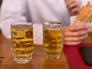 on the table are two full beer glasses next to each other