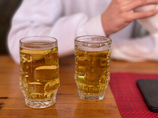 on the table are two full beer glasses next to each other