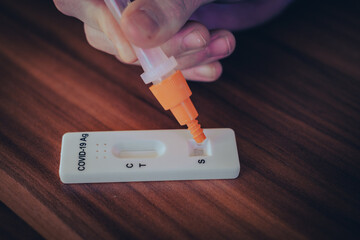 for a Covid 19 rapid test, liquid is dropped onto a test strip