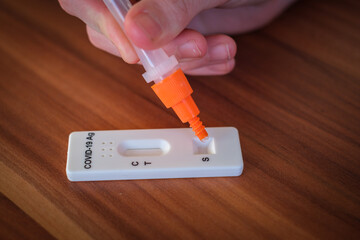 for a Covid 19 rapid test, liquid is dropped onto a test strip