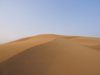 砂漠に形成される砂の山の尾根と青空