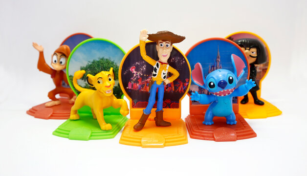 McDonald's happy meal toys in commemoration of the Walt Disney World 50th Anniversary celebration. Plastics figures. Isolated white. Woody, Simba, Stitch, Abu, Edna. Toy Story, The Lion King, Lilo.