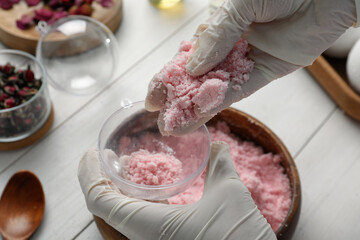 Woman in gloves making bath bomb at white table, closeup