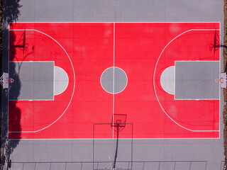 Partial overhead drone view of a red and gray basketball court