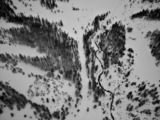 Winter black and white mountain landscape with crooked river