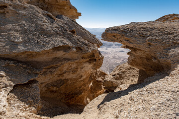 View of the Ramon Crater as seen between rocks on the summit of Mount Ardon Ramon Crater, Negev Desert, Southern Israel, Israel.