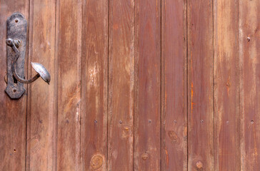 Old wooden door with metal handle, close up view. Background.