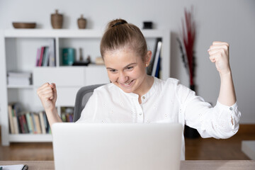 Front view of young woman celebrating good results on stock market.