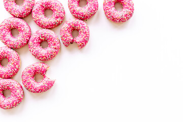 Set of pink glazed donutes with sprinkles, top view