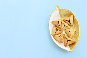 Purim celebration concept (jewish carnival holiday). Hamantaschen cookies over blue pastel background