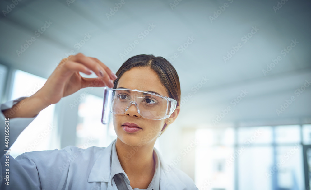 Poster this could be the cure. shot of a young scientist working in a lab.