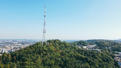 Aerial view of the large TV tower on the mountain in the urban area