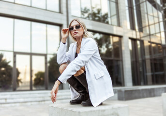 Fototapeta premium Young fashion blonde woman in trendy outfit posing in the city. Street fashion