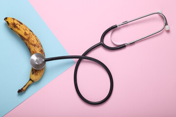 Bana with a stethoscope on a blue pink background. Treatment of male diseases, dysfunctions of the sexual system