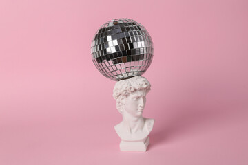 Bust of David with a disco ball on a pink background. Minimal party concept. Creative contemporary still life