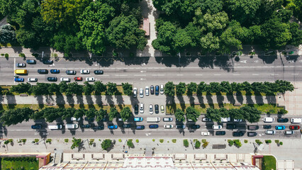 Aerial top view of a busy traffic road with cars near a park area in the city