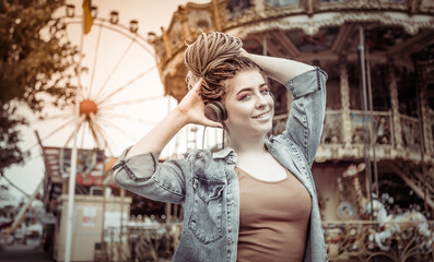 Extraordinary woman with African braids and flamboyant makeup spends time in an amusement park