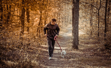 Sport Man runningon in forest with pet. Healthy active man jogging with dog