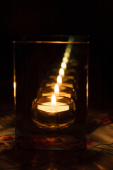 candle in a candlestick with parallel walls which give a lot of reflections