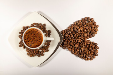 Heart shape made from coffee beans with a cup of coffee on white space.