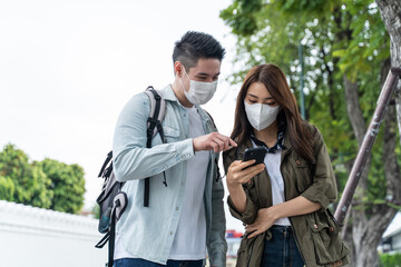 Fototapeta premium Asian romantic couple wear mask, travel in the city for honeymoon trip. 