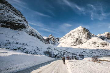 Fototapeta na wymiar Snowy mountain range and the road in winter on sunny day at Lofoten islands